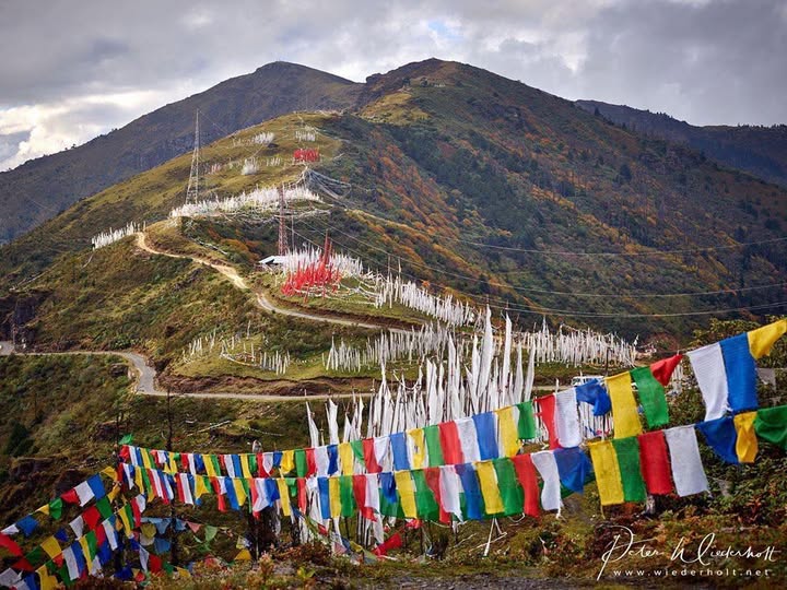 Chele La Pass in Bhutan with Himalayan mountain views, prayer flags, and scenic alpine landscape.