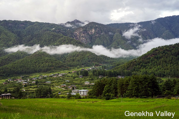 Genekha village with traditional Bhutanese houses, terraced fields, and green mountain landscapes near Thimphu during trek in Bhutan.