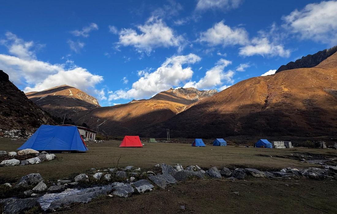 Jangothang valley with trekkers, yak pastures, and Mount Jomolhari in Bhutan.