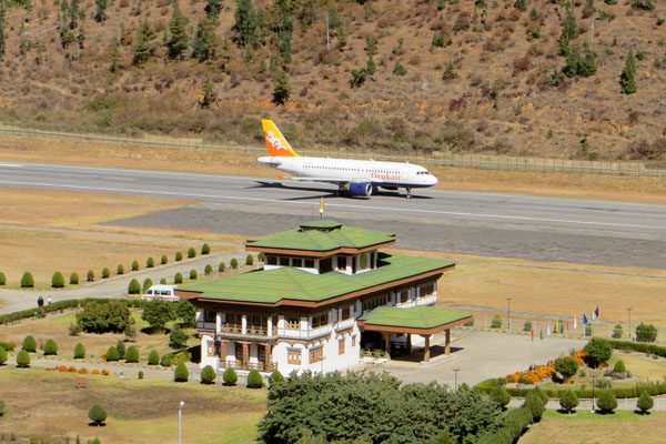 Paro International Airport with traditional Bhutanese architecture surrounded by scenic Himalayan mountains.