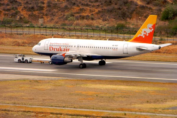 Paro International Airport surrounded by lush mountains and traditional Bhutanese architecture in Paro Valley, Bhutan.