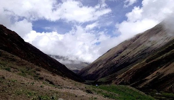 Shana campsite surrounded by Himalayan mountains and alpine forest in Bhutan.