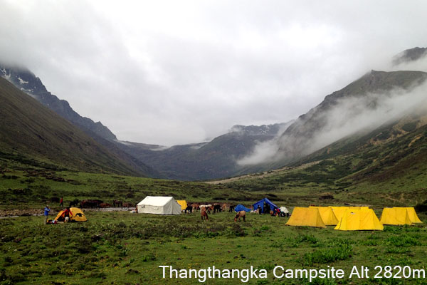 Thangthangkha campsite in Bhutan with alpine meadows, mountain streams, and Himalayan peaks along the trekking trail.
