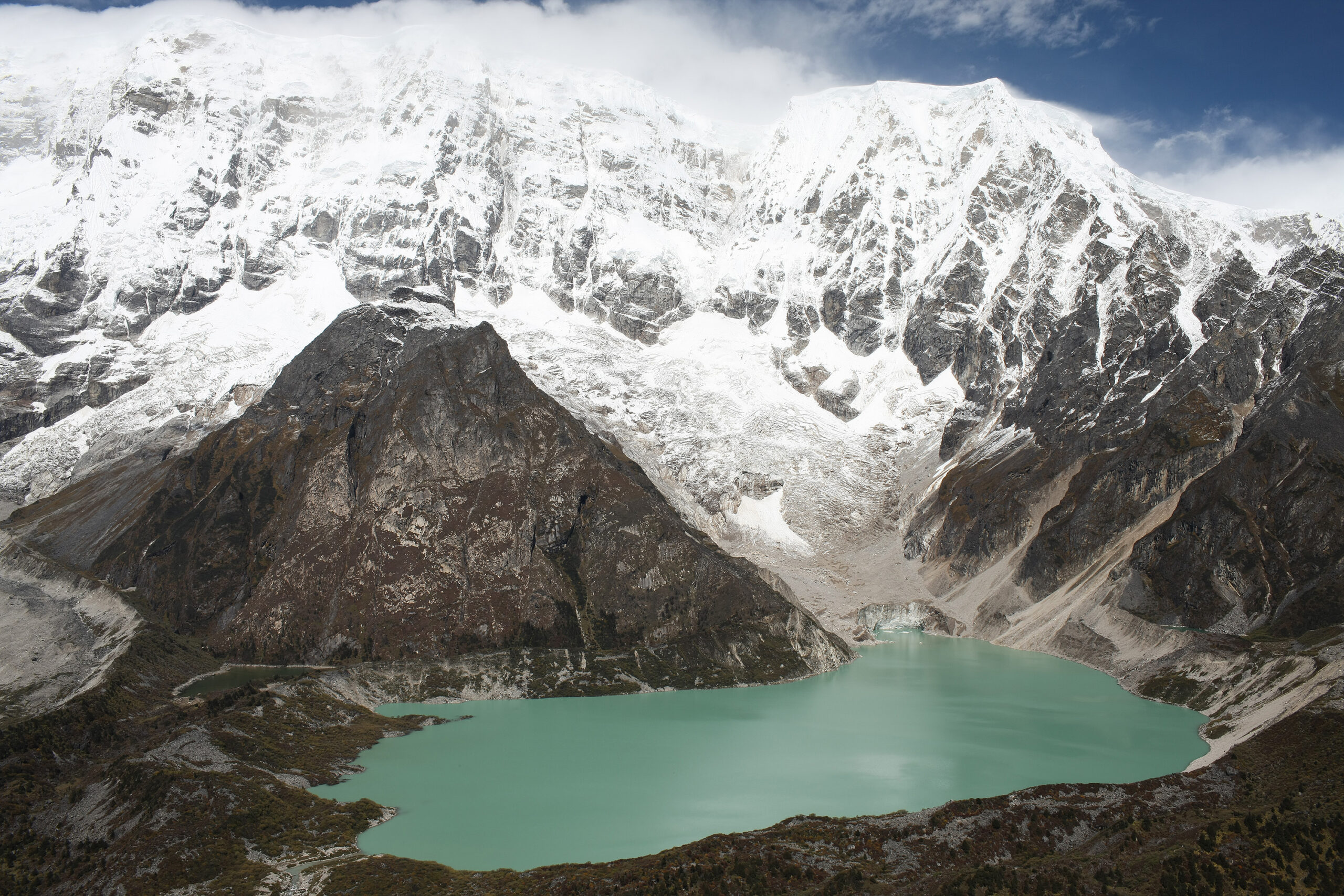 Thanza village in Bhutan surrounded by high Himalayan mountains, alpine meadows, and traditional mountain landscapes.