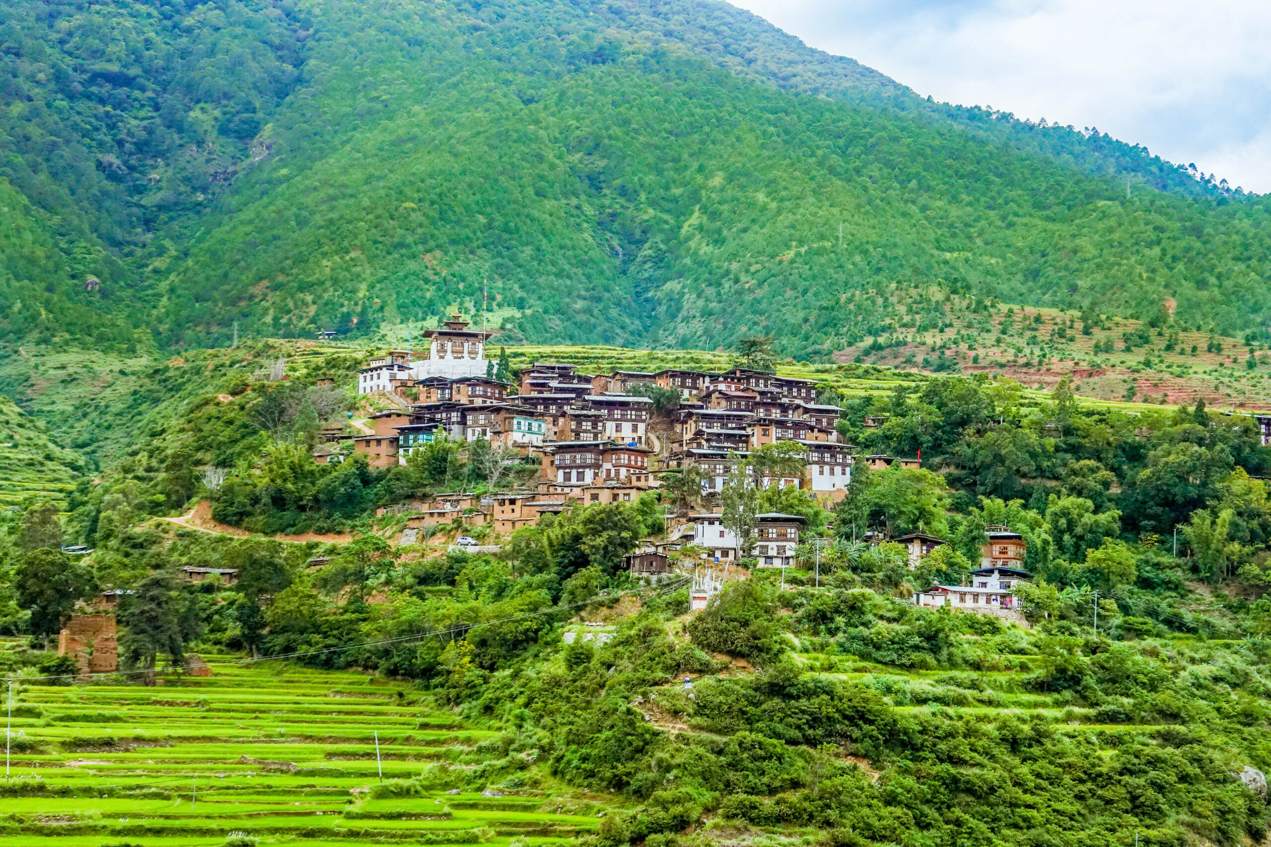 Wangdue Phodrang town with traditional Bhutanese buildings, Wangdue Phodrang Dzong, and surrounding mountain landscapes in Bhutan.